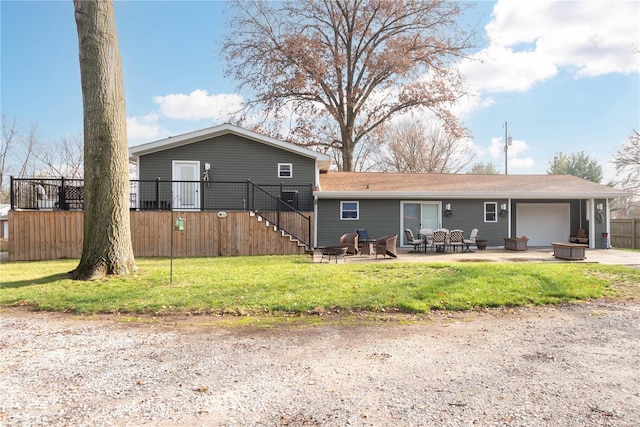 back of property with a lawn, a garage, and a patio