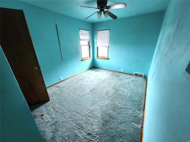 carpeted spare room featuring ceiling fan