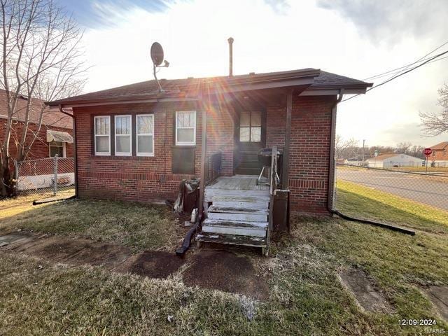 rear view of house featuring a lawn