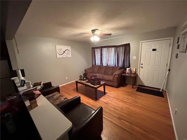 living room featuring ceiling fan and light hardwood / wood-style floors