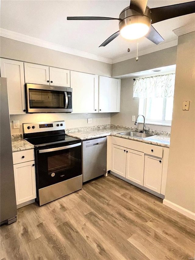 kitchen with white cabinets, light hardwood / wood-style floors, sink, and stainless steel appliances