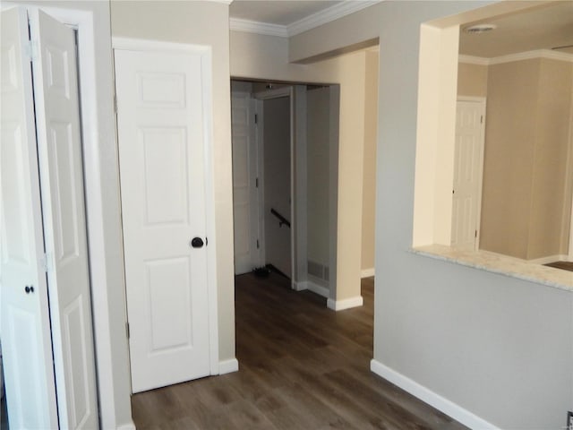 corridor with dark hardwood / wood-style flooring and ornamental molding