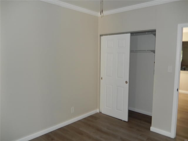 unfurnished bedroom featuring dark hardwood / wood-style flooring, crown molding, and a closet