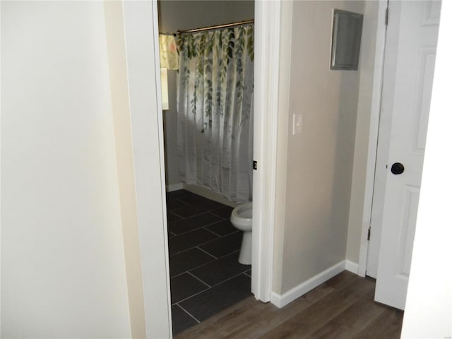 bathroom featuring hardwood / wood-style flooring, curtained shower, and toilet