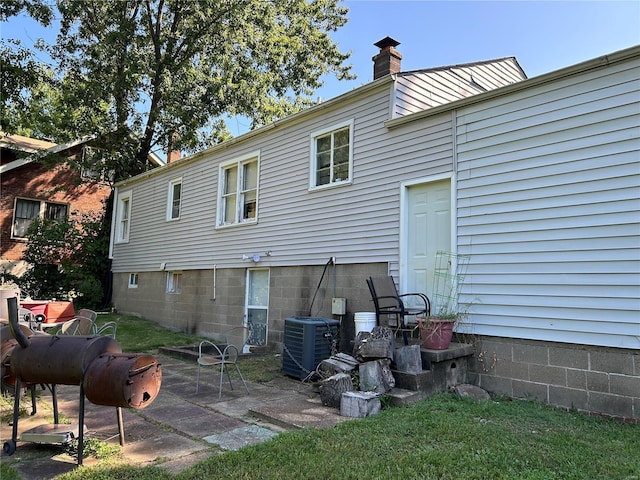 back of house with central AC unit