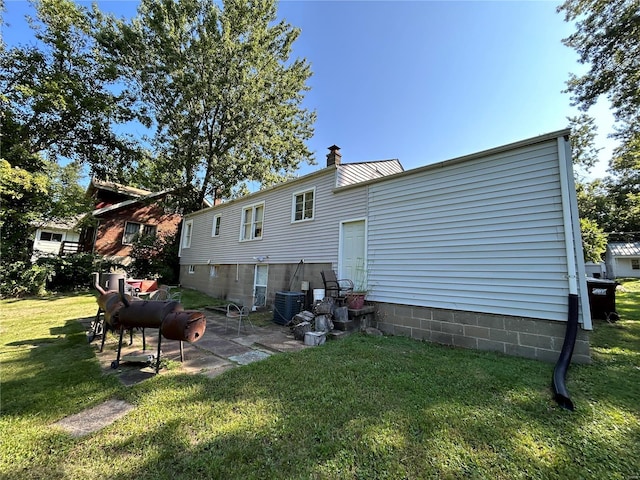 back of house featuring a yard and central AC unit