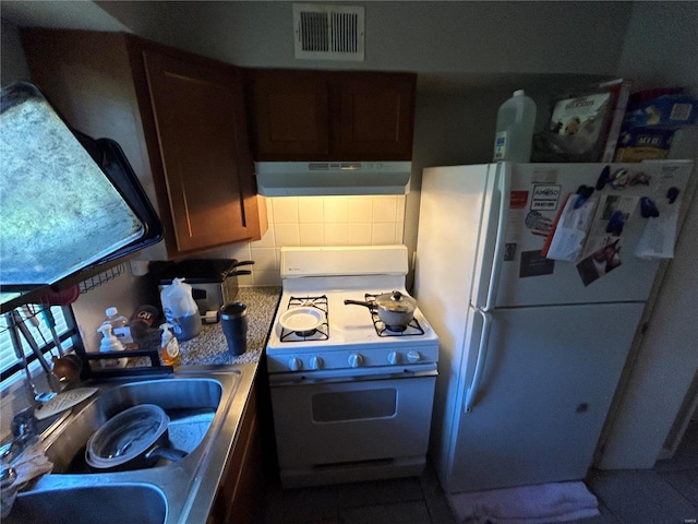 kitchen featuring tasteful backsplash, white appliances, sink, tile patterned flooring, and range hood