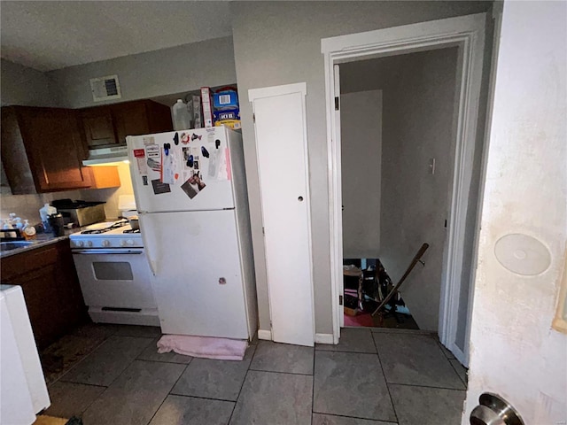 kitchen with tile patterned floors, white appliances, and sink