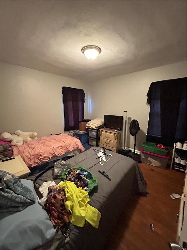 bedroom with dark hardwood / wood-style flooring