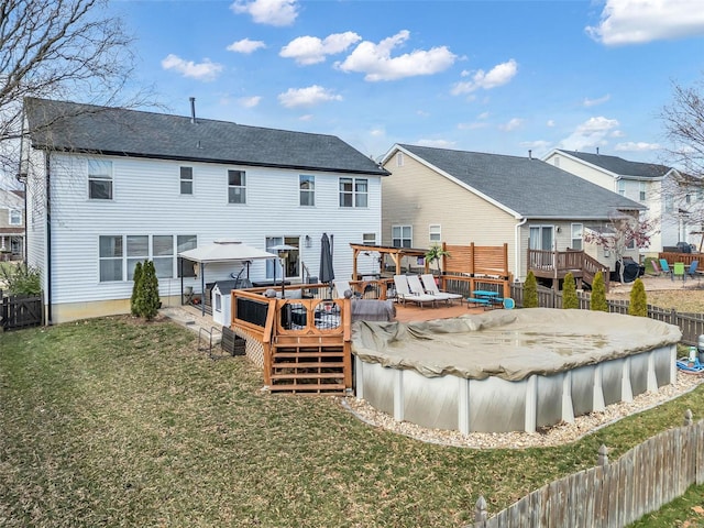 back of property featuring a pool side deck and a yard