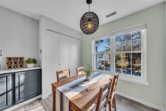 dining area featuring a healthy amount of sunlight, light wood finished floors, and visible vents