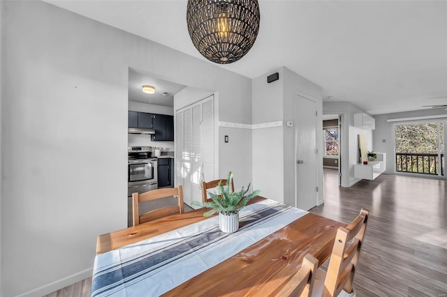 dining area with baseboards, a chandelier, and wood finished floors