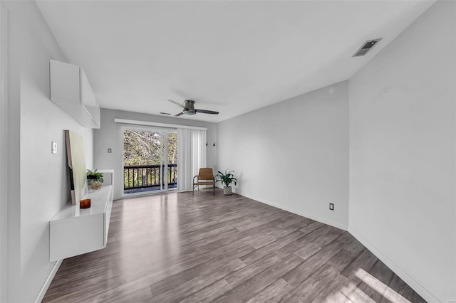 unfurnished room featuring ceiling fan, wood finished floors, visible vents, and baseboards