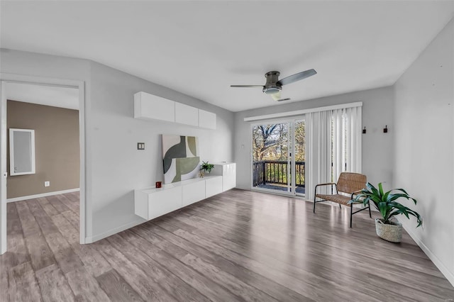 sitting room with a ceiling fan, visible vents, baseboards, and wood finished floors