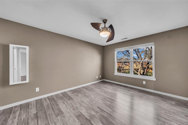 unfurnished room featuring visible vents, baseboards, ceiling fan, and wood finished floors