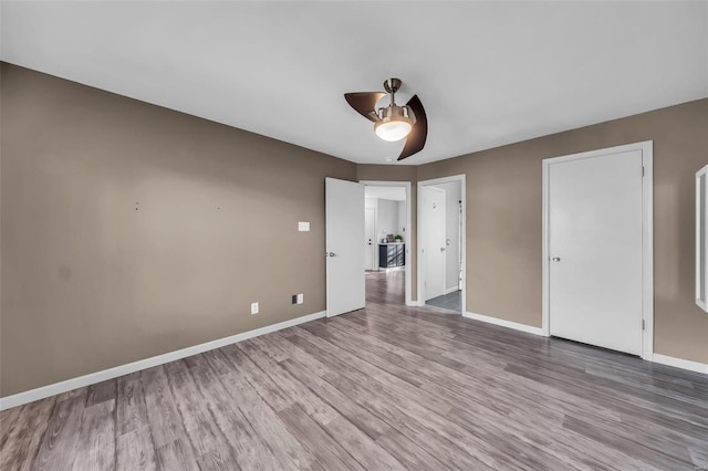 unfurnished bedroom with a ceiling fan, baseboards, and wood finished floors