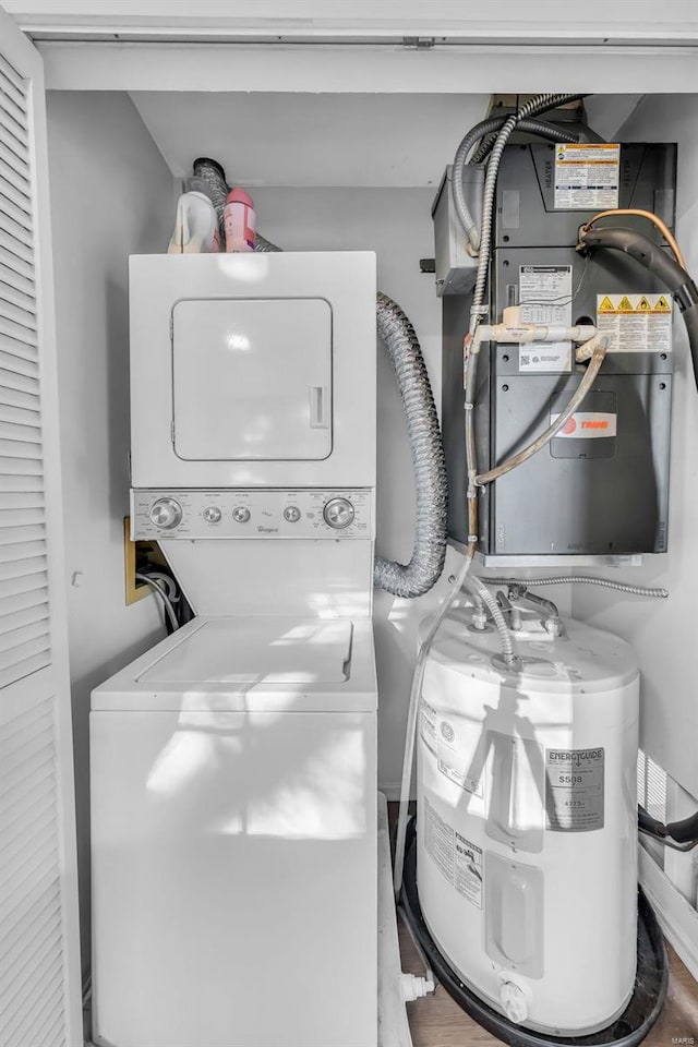 clothes washing area featuring stacked washer and dryer and laundry area