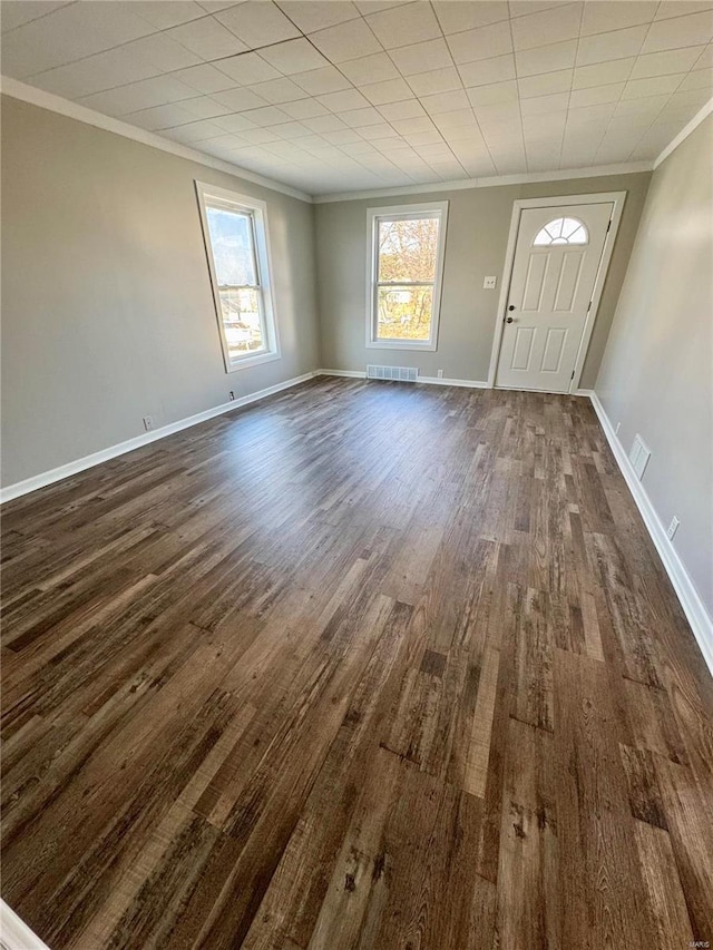 entrance foyer with a wealth of natural light, crown molding, and dark hardwood / wood-style floors