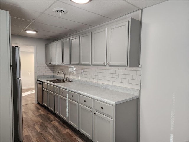 kitchen featuring gray cabinetry, sink, stainless steel appliances, dark hardwood / wood-style flooring, and backsplash