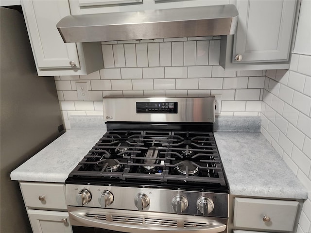 kitchen with gas stove, light stone counters, backsplash, and extractor fan