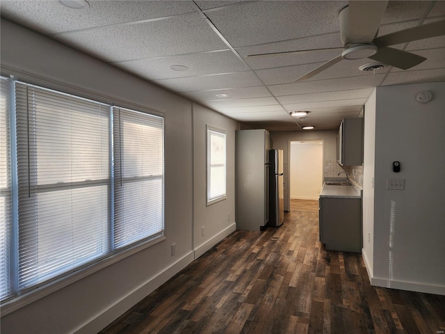 corridor with dark hardwood / wood-style flooring, a paneled ceiling, and sink