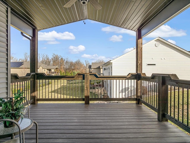 wooden deck with ceiling fan and a yard