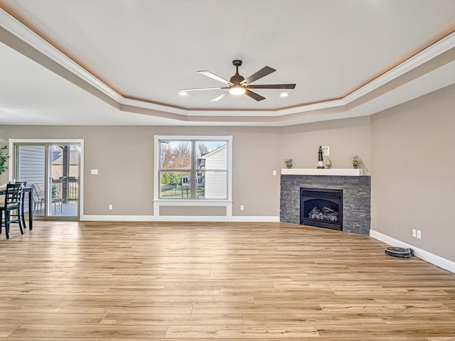 unfurnished living room with plenty of natural light, a stone fireplace, and light wood-type flooring