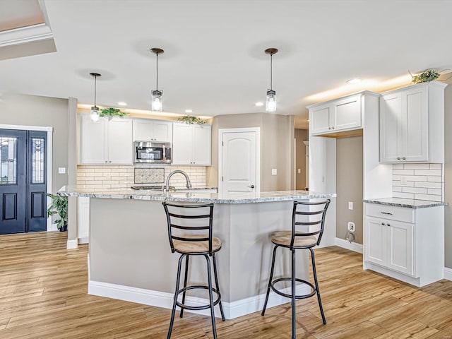 kitchen featuring white cabinetry, pendant lighting, and light wood-type flooring