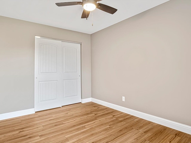 unfurnished bedroom featuring ceiling fan, a closet, and light hardwood / wood-style floors