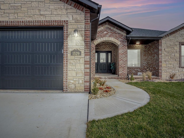 exterior entry at dusk featuring a garage