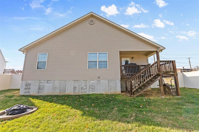 rear view of house with stairway, fence, a lawn, and a wooden deck