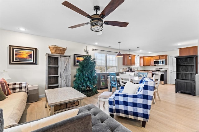 living area featuring a ceiling fan, light wood-type flooring, and recessed lighting