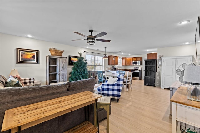 living room with light wood-style floors, ceiling fan, and recessed lighting