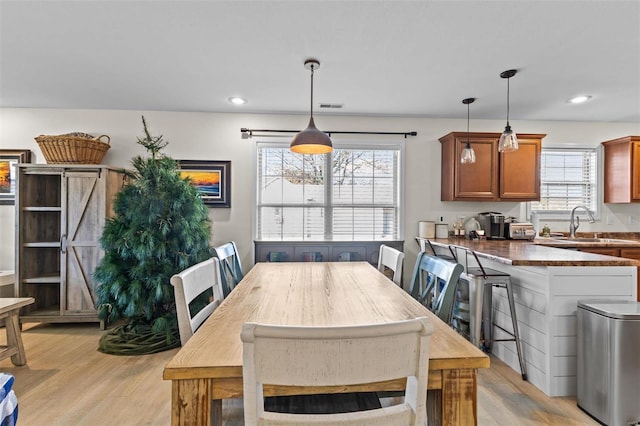 dining area featuring light wood finished floors, visible vents, and recessed lighting