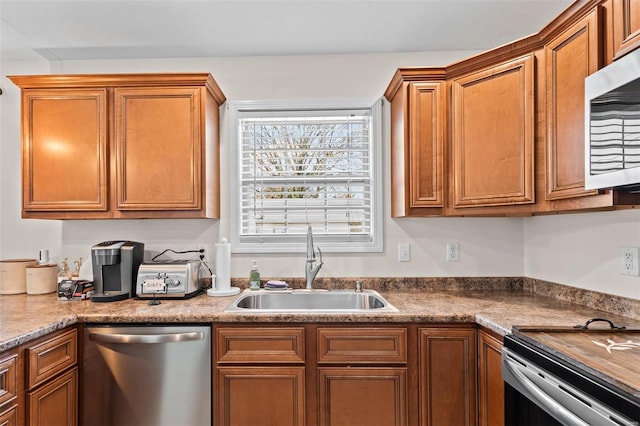 kitchen featuring stainless steel appliances, brown cabinetry, and a sink