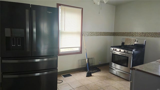 kitchen featuring gas range, black fridge, and ceiling fan