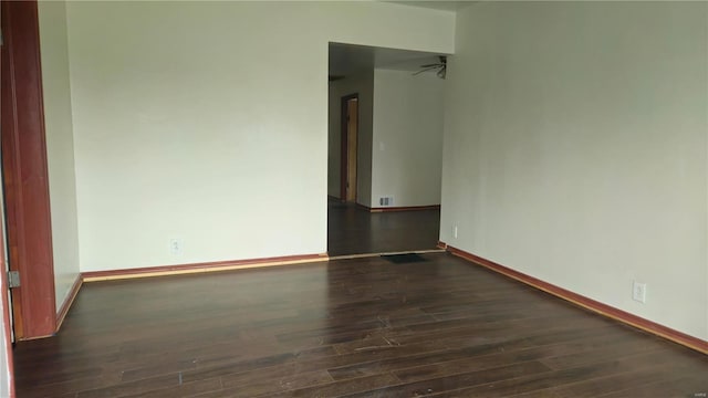 empty room featuring ceiling fan and dark wood-type flooring