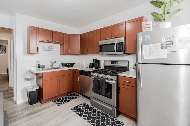 kitchen featuring light hardwood / wood-style floors, sink, and appliances with stainless steel finishes