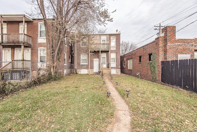 view of front of property with a balcony and a front lawn