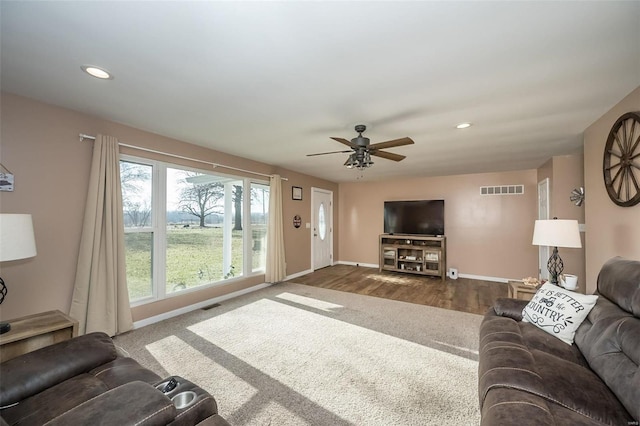 living room with ceiling fan and dark hardwood / wood-style flooring