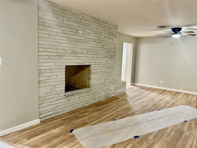 unfurnished living room featuring ceiling fan, a fireplace, and hardwood / wood-style flooring