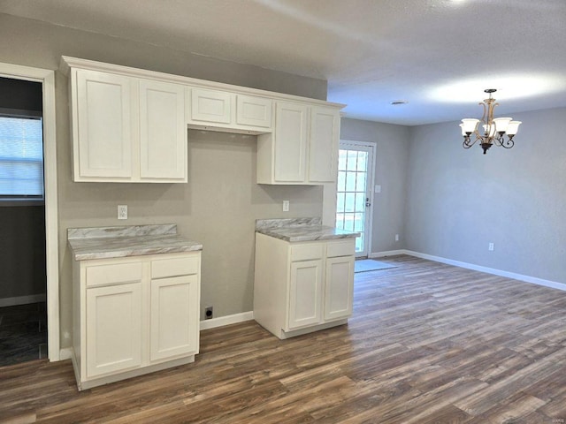 kitchen featuring a notable chandelier, hanging light fixtures, white cabinets, and dark hardwood / wood-style flooring