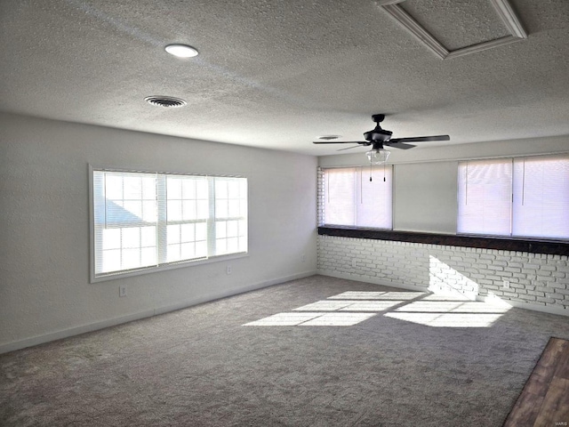 carpeted empty room featuring ceiling fan and a textured ceiling