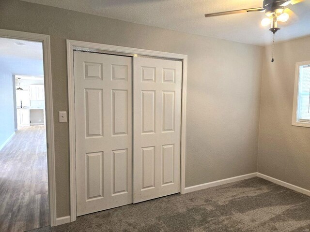 unfurnished bedroom with carpet flooring, ceiling fan, and a closet