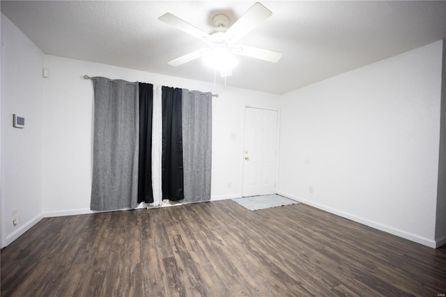 unfurnished room with ceiling fan and dark wood-type flooring