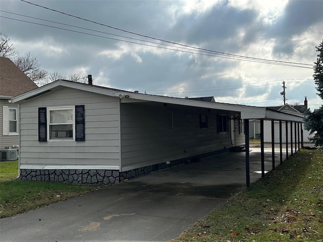 view of home's exterior with a carport and central AC