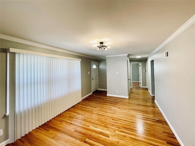 empty room featuring light hardwood / wood-style flooring and ornamental molding