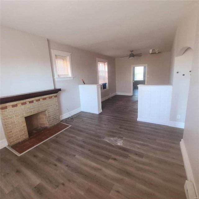 unfurnished living room with dark hardwood / wood-style floors, a brick fireplace, and ceiling fan