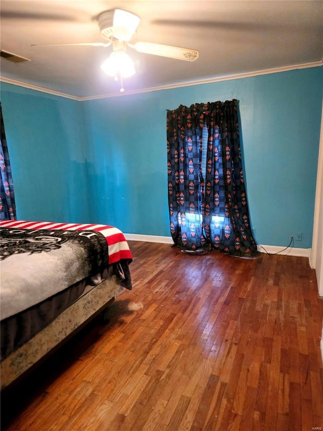 bedroom featuring hardwood / wood-style floors, ceiling fan, and crown molding