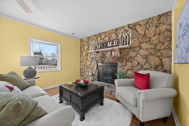 living room featuring a fireplace, wood-type flooring, and ceiling fan